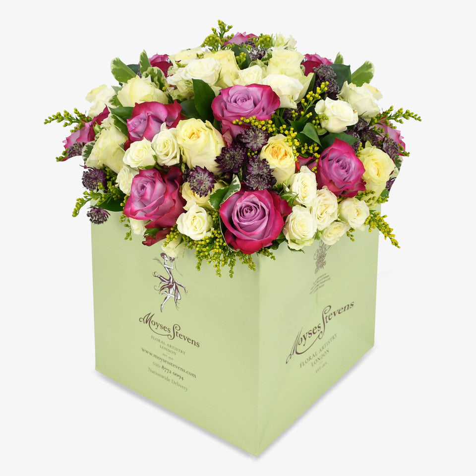 Lemon Meringue luxury flower bouquet by Moyses Stevens UAE featuring yellow and deep purple roses, white spray roses, solidago and astrantia and seasonal greenery.